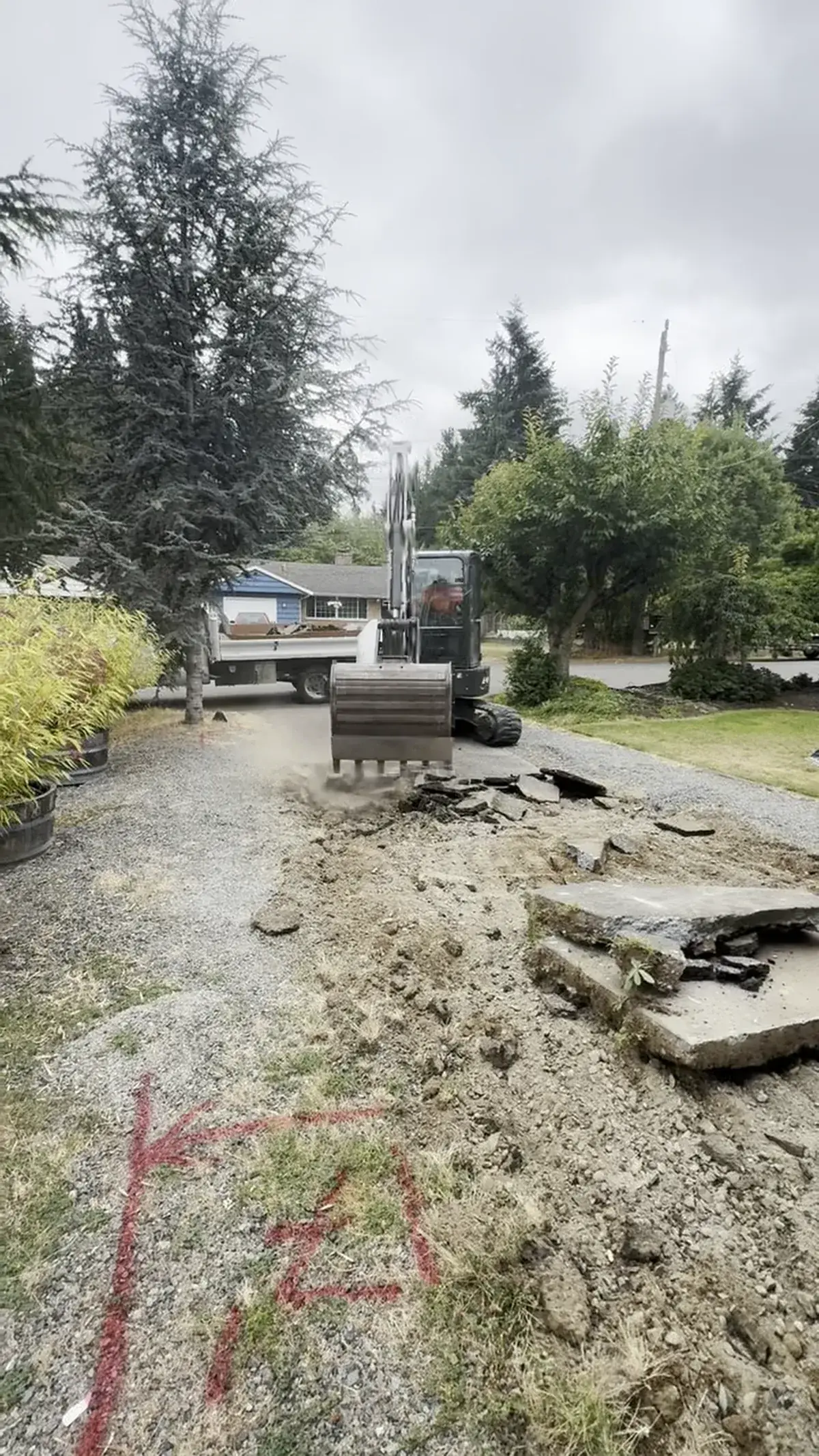 DirtRaptor excavator breaking out old material with a dump truck staged for haul-off